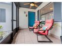 Inviting screened-in front porch with tiled floor, ceiling fan, and comfortable seating by the front door at 609 Doheny Way, Casselberry, FL 32707