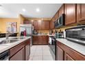 Well-equipped kitchen featuring dark wood cabinetry, stainless steel appliances, and tile flooring at 739 Jefferson, Davenport, FL 33837