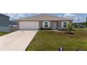 Charming single-story home featuring a well-manicured lawn and attached two-car garage at 761 Parrot Ct, Kissimmee, FL 34759