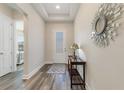 Bright entryway with wood floors, a decorative mirror, and a stylish console table at 7834 Stoney Bay Loop, Kissimmee, FL 34747