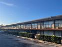 Low angle shot of a multi-unit exterior with a long row of rooms, black railing, and partial parking lot at 7900 S Orange Blossom Trl # 2136, Orlando, FL 32809