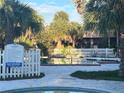 Leisure pool with a white fence and pool rules sign surrounded by large palm trees at 7900 S Orange Blossom Trl # 2136, Orlando, FL 32809
