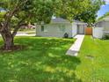 Well-maintained front lawn leading up to a cozy single-story home, shaded by a mature tree at 1501 Delaware Ave, St Cloud, FL 34769