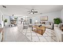 Bright, open-concept living area with modern tile floors, neutral decor, and a ceiling fan at 1501 Delaware Ave, St Cloud, FL 34769