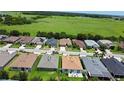 Aerial view of a quiet suburban neighborhood with green spaces and ponds in the background at 2829 Shelburne Way, St Cloud, FL 34772