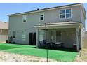 Spacious backyard featuring a covered patio with lighting and artificial grass at 3252 Jackson Bluff Way, Clermont, FL 34711