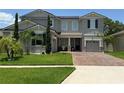 Beautiful home with manicured lawn, brick driveway, stone accents, and lush landscaping at 3252 Jackson Bluff Way, Clermont, FL 34711