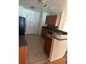 Practical kitchen with tile floors, wooden cabinets, and standard appliances at 506 Myakka Pl, Kissimmee, FL 34759