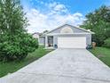 Single-story home with a two-car garage, featuring an established front yard at 739 Paris Dr, Kissimmee, FL 34759