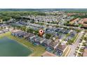 Aerial view of the neighborhood with waterfront homes and a large pond at 1006 Tourmaline Dr, Kissimmee, FL 34746