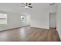 Bright living room featuring wood floors, ceiling fan, and natural light from two windows at 14927 Sw 25Th Cir, Ocala, FL 34473