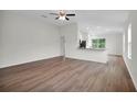 Open concept living room with wood flooring, a ceiling fan, and view into the modern kitchen at 14927 Sw 25Th Cir, Ocala, FL 34473