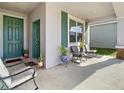 Inviting front porch with seating, green door, and ample space for relaxation at 590 Tanaro Ln, Haines City, FL 33844