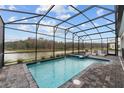 Screened-in pool area with hot tub overlooking tranquil lake views and comfortable lounge chairs at 2901 Protagonist St, Kissimmee, FL 34746