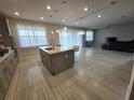Bright kitchen featuring a center island, stainless steel appliances, and seamless flow into the living area at 2659 Park Ridge St, Apopka, FL 32712