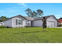 View of the charming gray home, showcasing its well-maintained lawn and inviting facade at 2722 Sw 151St Pl, Ocala, FL 34473
