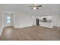 Open-concept living room with wood flooring flowing into a modern kitchen with white cabinets at 2722 Sw 151St Pl, Ocala, FL 34473