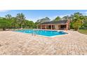 Community pool with brick patio and covered seating area at 565 Lake Mystic Ln, Lakeland, FL 33813