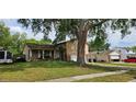 Inviting home featuring a two-car garage and lush yard with mature tree at 1814 Lowry Ave, Lakeland, FL 33801