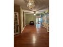 Spacious living room featuring hardwood floors, decorative chandelier and natural lighting at 1219 Dixie Dr, Auburndale, FL 33823