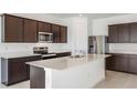 Modern kitchen with dark brown cabinets, stainless steel appliances, and an island at 4390 Sw 84Th Street Rd, Ocala, FL 34476
