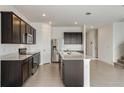 Modern kitchen with dark brown cabinets, stainless steel appliances, and an island at 4390 Sw 84Th Street Rd, Ocala, FL 34476