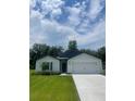 Inviting one-story home showcasing a well-kept lawn, a convenient two-car garage, and lovely landscaping at 4270 Sw 143Rd Lane Rd, Ocala, FL 34473