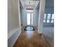 Inviting foyer with decorative tile, chandelier, and grand columns defining the entrance to the home at 5446 Pebble Beach Dr, Lakeland, FL 33812