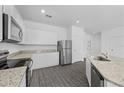 Modern kitchen with white cabinets, stainless steel appliances, and granite countertops at 567 Bay Leaf Dr, Poinciana, FL 34759