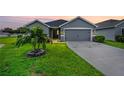 Gray house with a two-car garage and lush green lawn in the front at 6388 Gardner Dr, Lakeland, FL 33813