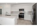 Well-lit kitchen with stainless steel appliances, white cabinets and a stylish backsplash at 6826 Sw 90Th Loop, Ocala, FL 34476