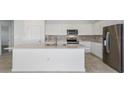 Modern kitchen featuring white cabinets, stainless steel appliances, and a large kitchen island at 6833 Sw 90Th Loop, Ocala, FL 34476