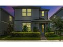 Charming two-story home featuring a beautifully landscaped front yard and stylish architectural details at 14234 Lanikai Beach Dr, Orlando, FL 32827