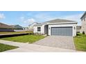 New construction home exterior with gray siding and a gray garage door at 5753 Wallis Ln, St Cloud, FL 34771