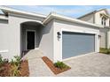 Modern home exterior with gray siding, walkway, and gray garage door at 5753 Wallis Ln, St Cloud, FL 34771