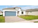 Curb appeal of a one-story home with gray garage door at 5783 Greenery Ln, St Cloud, FL 34771