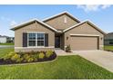 Charming single-Gathering home with a manicured lawn, neat flowerbeds, and a two-car garage at 684 Se 65Th Ter, Ocala, FL 34472