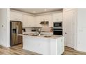 Bright kitchen with stainless steel appliances, white cabinetry, an island with a sink, and stylish countertops at 4412 Sw 84Th Street Rd, Ocala, FL 34476