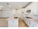 Bright kitchen featuring white cabinetry, stainless appliances, an island, and modern backsplash at 4457 Sw 84Th Street Rd, Ocala, FL 34476