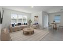 Bright living room featuring a neutral palette, stylish furnishings, and ample natural light from a large window at 4416 Sw 84Th Street Rd, Ocala, FL 34476