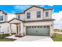 Two-story house with beige siding, gray garage door, and landscaping at 3740 Bergamot St, Lake Alfred, FL 33850