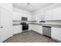 Modern kitchen featuring white cabinets, granite countertops, and stainless steel appliances at 3732 Bergamot St, Lake Alfred, FL 33850