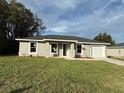 Charming gray home with a well-manicured lawn and a freshly sealed driveway at 13371 Sw 112Th Pl, Dunnellon, FL 34432
