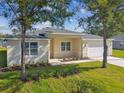 Charming one-story home with a well-manicured lawn and a light-colored facade at 2511 Avenue E Sw, Winter Haven, FL 33880