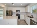 Modern kitchen with stainless steel appliances, white cabinets, a large island, and a tile backsplash, perfect for cooking at 9080 Wildlight Trl, Wildwood, FL 34785