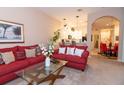 Inviting living room with stylish red sofas, glass coffee table, and open view to the kitchen and dining area at 308 New Providence # 308, Davenport, FL 33897