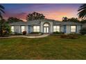 Charming one-story home with colorful sunset, manicured lawn, and lush landscaping at 5407 County Road 125, Wildwood, FL 34785