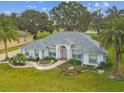 Charming single-story home featuring a well-manicured lawn and palm trees at 5407 County Road 125, Wildwood, FL 34785