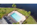 Community pool with lounge chairs; located lakeside with palm trees at 116 Prestwick Grande Dr, Daytona Beach, FL 32124