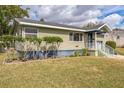 One-story house featuring a light green exterior, neatly trimmed landscaping, and a covered entrance at 836 Kensington St, Lakeland, FL 33803